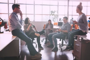 Mitarbeiter machen gemeinsam eine Mittagspause im Büro und unterhalten sich.